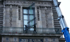 Des ouvriers installent une grille de protection devant la fenêtre de la galerie d'Apollon du  musée du Louvre, le 23 décembre 2025 à Paris ( AFP / Dimitar DILKOFF )