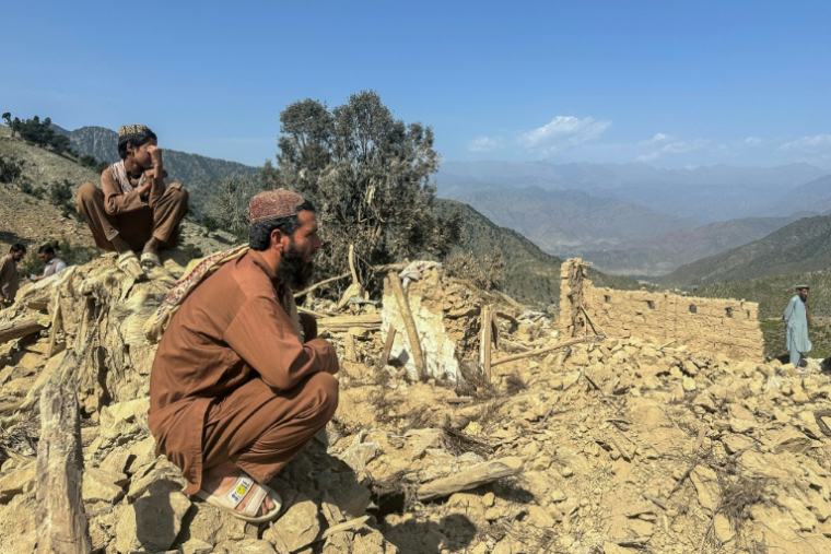Des habitants afghans sont assis à côté de leurs maisons détruites par une frappe aérienne pakistanaise dans le district de Shultan, dans la province de Kunar, en Afghanistan, le 1er octobre 2026 ( AFP / Aimal Zahir )
