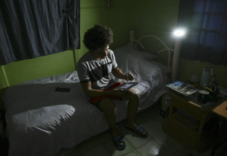 Alfredo Rodriguez, professeur de design, travaille pendant une coupure d'électricité dans le quartier de Punta Brava, à La Havane, le 11 mai 2026 ( AFP / YAMIL LAGE )