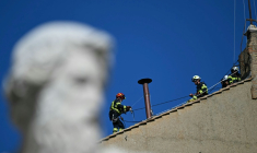 Des pompiers installent la cheminée sur le toit de la chapelle Sixtine le 2 mai 2025 ( AFP / Gabriel BOUYS )
