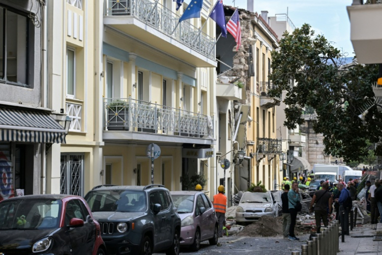 Des équipes de secours sur le site d'un immeuble partiellement effondré après une explosion dans le quartier de Plaka, au centre d'Athènes, le 25 septembre 2026 en Grèce ( AFP / Aris MESSINIS )
