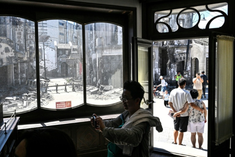 Des touristes chinois visitent le lieu de tournage du film "Dead to Rights" à Shanghai, le 27 août 2025  en Chine ( AFP / Hector RETAMAL )