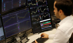 Un trader travaille à son bureau chez CMC Markets dans la City de Londres