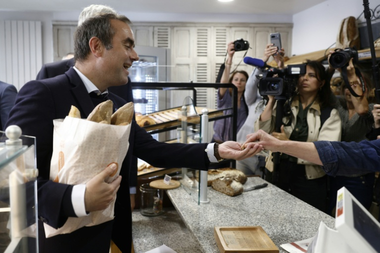 Le Premier ministre Sébastien Lecornu achète du pain dans une boulangerie à l'occasion de la Fête du Travail à Saint-Julien-Chapteuil, le 1er mai 2026 en Haute-Loire ( POOL / Kenzo TRIBOUILLARD )