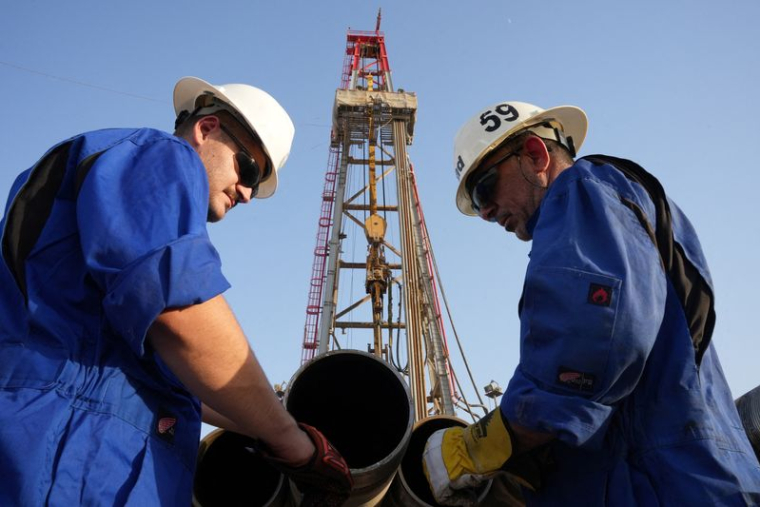 Des ouvriers travaillent sur un site de forage dans un champ pétrolifère, en Irak