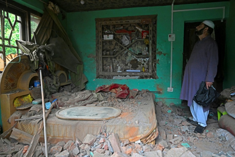 Un habitant inspecte sa maison endommagée par les tirs d'artillerie pakistanais à Uri, à environ 100 km de Srinagar, le 9 mai 2025 en Inde ( AFP / Tauseef MUSTAFA )