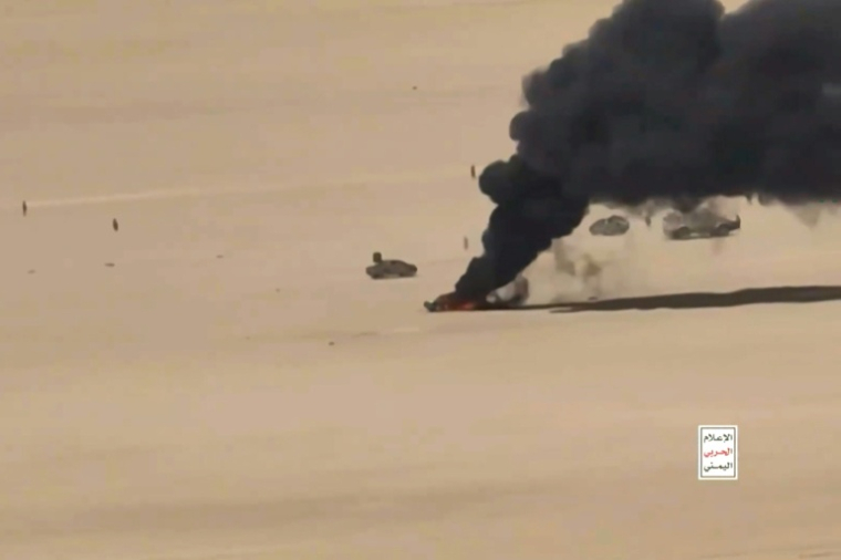 TImage tirée d'une vidéo diffusée par le centre médiatique d'Ansarullah le 5 octobre 2026 montrant une vue aérienne d'un véhicule en feu lors de ce que les Houthis présentent comme des attaques de drones contre les forces gouvernementales yéménites, dans un endroit non précisé au Yémen ( ANSARULLAH MEDIA CENTRE / Handout )