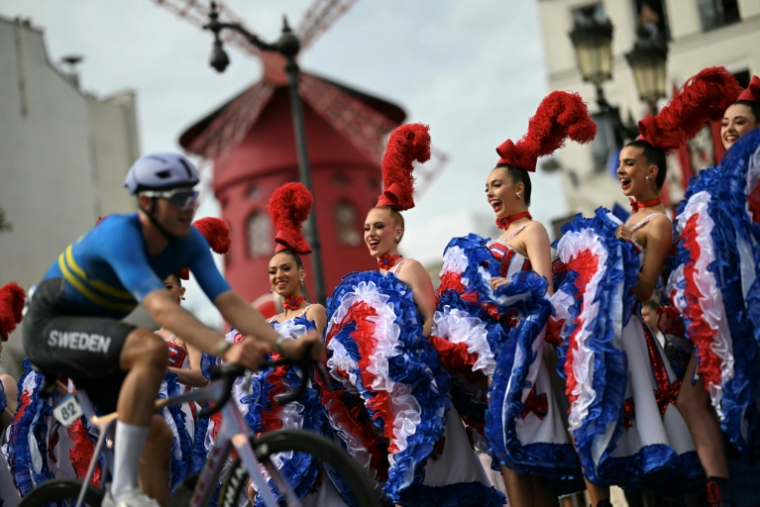 Les danseuses du Moulin Rouge lors de la course cycliste sur route masculine des Jeux Olympiques de Paris 2024 à Paris, le 3 août 2024 ( AFP / Mauro PIMENTEL )