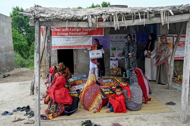 Des travailleuses sociales (d) enseignent à des mères comment préparer des repas nutritifs pour leurs enfants lors d'un programme de nutrition de l'Unicef au village de Fateh Muhammad Soomro, dans la province du Sindh, le 29 juillet 2025 au Pakistan ( AFP / Rizwan TABASSUM )