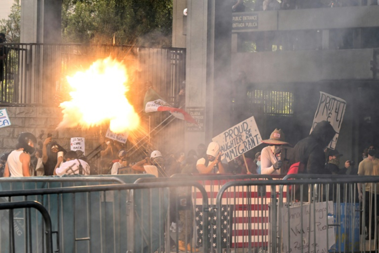Une grenade assourdissante explose alors que la police tente de disperser les manifestants après le rassemblement "No Kings" devant l'hôtel de ville de Los Angeles, le 14 juin 2025 en Californie ( AFP / RONALDO SCHEMIDT )