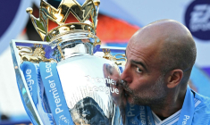 Pep Guardiola embrasse le trophée de la Premier League, le 19 mai 2024 à l'Etihad Stadium ( AFP / Oli SCARFF )