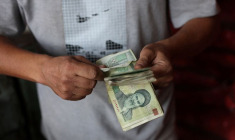 Un commerçant tient des rials iraniens dans un marché local de Téhéran