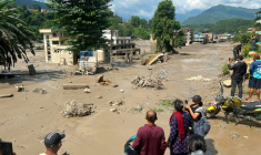 Des habitants observent des maisons partiellement submergées dans des eaux boueuses à la suite d'inondations soudaines survenues à Trishuli Bazar, dans le district de Nuwakot au Népal, le 26 août 2026. ( AFP / Prakash MATHEMA )