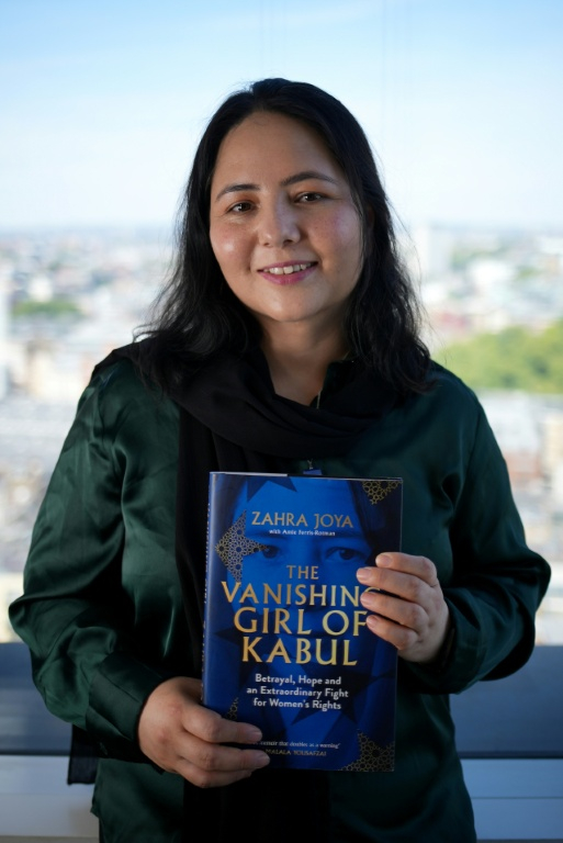 La journaliste afghane Zahra Joya pose à l'issue d'un entretien à l'AFP avec son livre "The Vanishing Girl of Kabul" (La jeune fille disparue de Kaboul),  le 14 août 2026 à Londres  ( AFP / Yelim LEE )