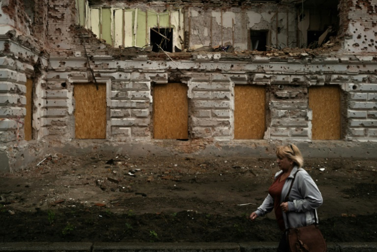 Une femme passe à proximité d'un bâtiment détruit par un bombardement russe, le 12 juin 2025 à Soumy, dans le nord-est de l'Ukraine ( AFP / Florent VERGNES )