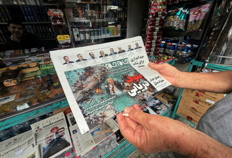 La une du journal Jam Jam, en vente dans un kiosque à Téhéran, présentant un dessin humoristique du président américain Donald Trump se noyant dans le détroit d'Ormuz avec le titre "Bluff maritime", le 13 avril 2026 en Iran ( AFP / ATTA KENARE )