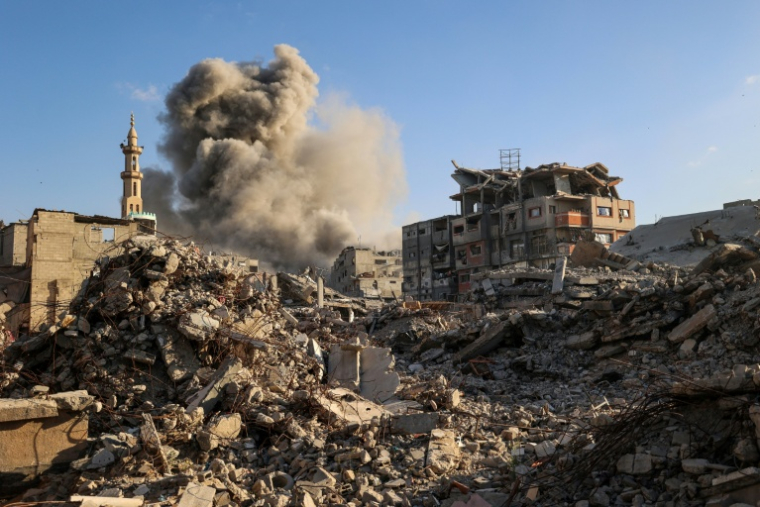 Un nuage de fumée s'élève après une frappe israélienne qui a visé un bâtiment dans le camp de réfugiés palestiniens de Bureij, dans le centre de la bande de Gaza, le 19 octobre 2025 ( AFP / Eyad BABA )