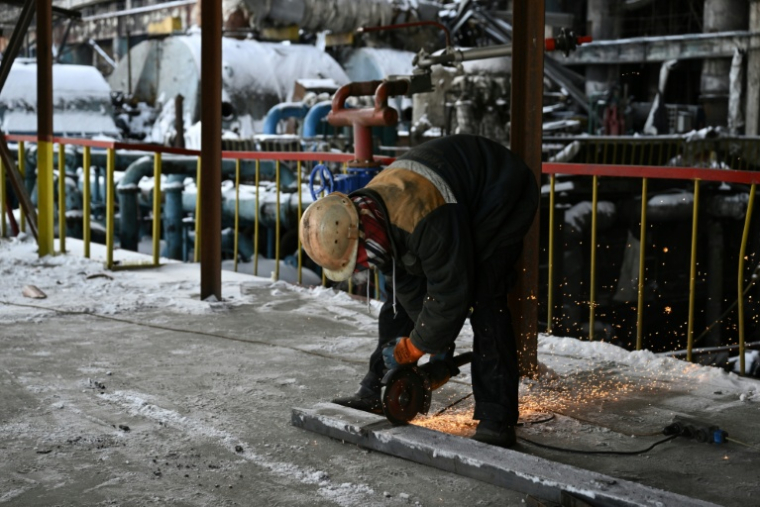 Un employé dégage des débris dans une centrale thermique fortement endommagée du fournisseur d’énergie ukrainien DTEK, dans un lieu tenu secret en Ukraine, le 9 février 2026, à la suite de frappes russes. ( AFP / Genya SAVILOV )
