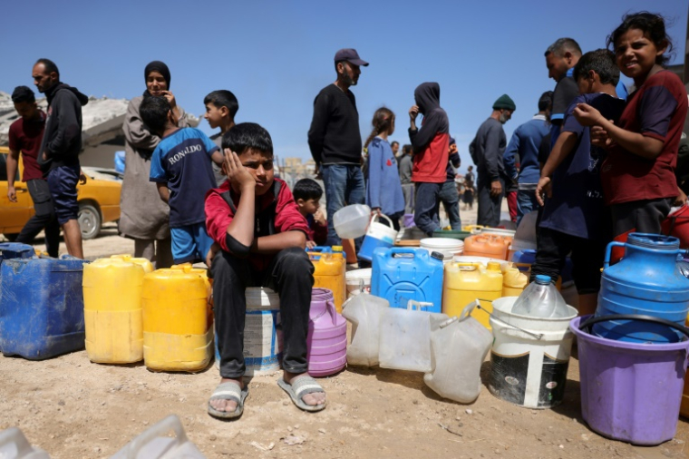 Des Palestiniens attendent de pouvoir obtenir de l'eau dans un camp de personnes déplacées à Gaza-Ville, le 20 mai 2025, sur fond de guerre entre Israël et le mouvement palestinien Hamas ( AFP / Bashar TALEB )