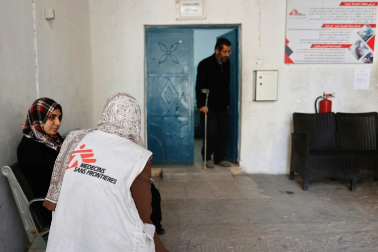 Un membre du personnel de Médecins Sans Frontières (MSF) s'entretient avec une femme qui se rend dans une clinique du quartier d'al-Rimal, à Gaza, la veille du Nouvel An, le 31 décembre 2025 ( AFP / Omar AL-QATTAA )