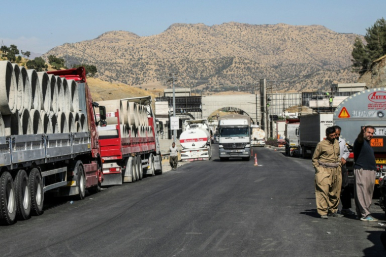 Des chauffeurs de camion iraniens attendent de pouvoir repasser la frontière iranienne dans le district de Penjwen, près de la frontière avec l'Iran, dans la région autonome du Kurdistan irakien, le 21 septembre 2026 ( AFP / Safin HAMID )
