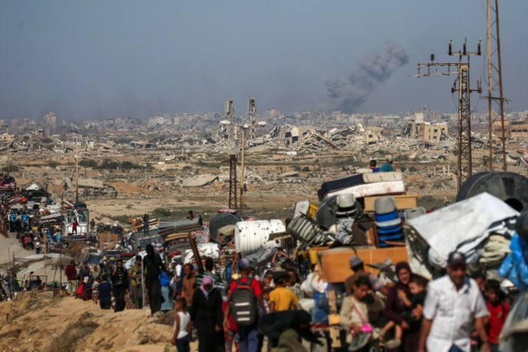 Des Palestiniens se déplacent avec leurs affaires vers le sud de la bande de Gaza sur une route côtière dans la zone du camp de réfugiés de Nousseirat après de nouveaux ordres d'évacuation israéliens pour la ville de Gaza le 14 septembre 2025 ( AFP / Eyad BABA )