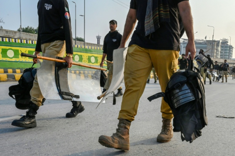 Des policiers se dirigent vers leur zone de déploiement dans le contexte des manifestations en cours du parti d’opposition Pakistan Tehreek-e-Insaf (PTI), qui réclame la libération de l’ancien Premier ministre Imran Khan, actuellement emprisonné, à Peshawar, le 11 octobre 2026 ( AFP / Abdul MAJEED )