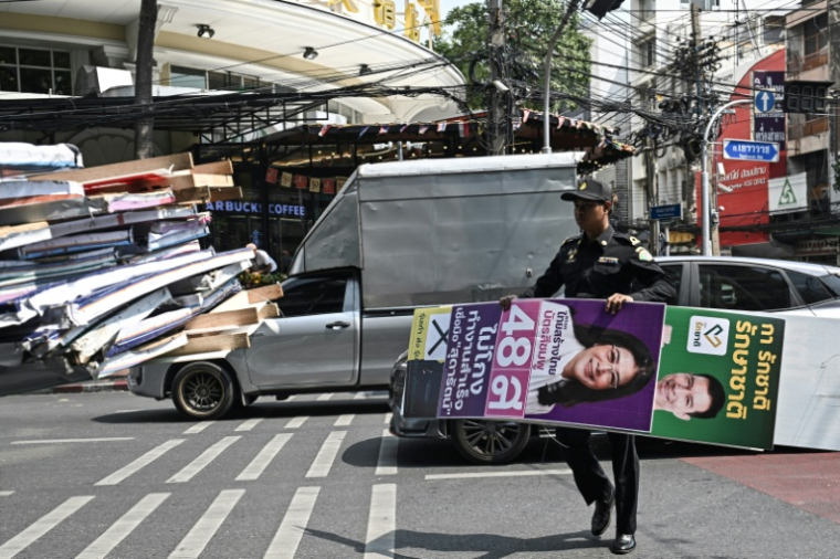 Des employés de la ville de Bangkok retirent les affiches électorales au lendemain des élections, le 9 février 2026 en Thaïlande ( AFP / Lillian SUWANRUMPHA )