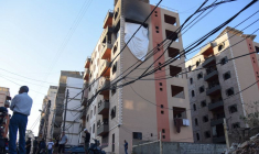 Des personnes se tiennent sur le site touché par une frappe israélienne dans la ville de Tripoli, au Liban