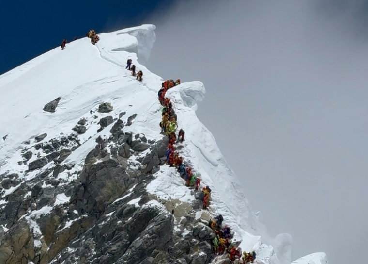 Des alpinistes gravissent une pente en file indienne pour atteindre le sommet de l’Everest, au Népal, le 20 mai 2026 ( AFP / Furte Sherpa )
