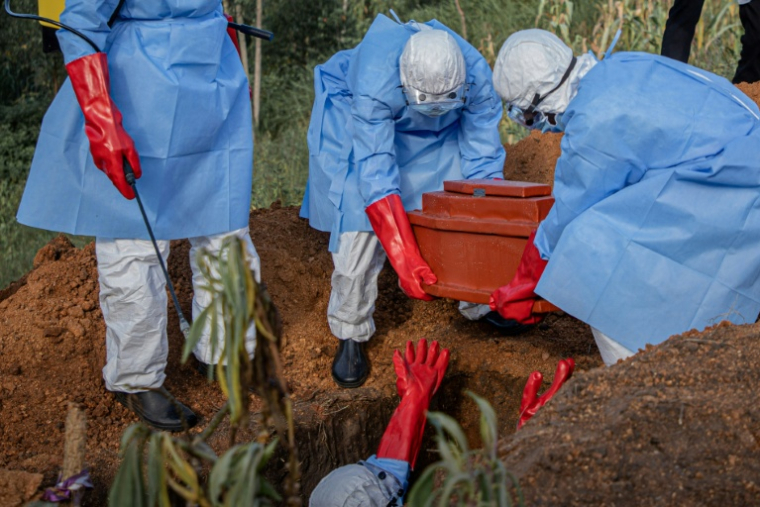 Des volontaires déposent le cercueil d’un enfant de 3 ans, présumé mort d'Ebola, lors de ses funérailles dans un cimetière de Bunia (RDCongo), le 11 juin 2026 ( AFP / Benediction MURHABAZI )