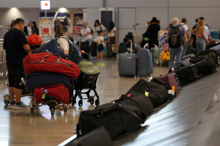 Des voyageurs attendent leur bagages à leur arrivée à l'aéroport Ben Gourion, le 25 juin 2025 à Tel-Aviv, en Israël ( AFP / Jack GUEZ )