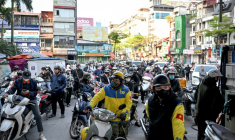 Des motocyclistes font la queue pour faire le plein d'essence dans une station-service à Hanoï, le 10 mars 2026 au Vietnam ( AFP / Nhac NGUYEN )