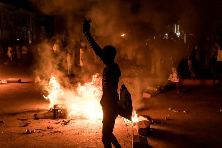 Un manifestant se tient près d'une barricade lors d'un rassemblement spontané à Brusubi en Gambie le 8 septembre 2026, pour protester contre des semaines de coupures d'électricité prolongées dans le pays   ( AFP / Muhamadou BITTAYE )
