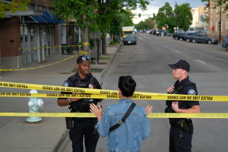 Des policiers parlent avec un passant sur les lieux d'une attaque contre des manifestants pour la libération d'otages israéliens retenus à Gaza, sur Pearl Street à Boulder, le 1er juin 2025 dans le Colorado ( AFP / Eli Imadali )