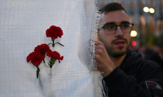 Un manifestant tient une bannière avec des oeillets rouges lors de la marche annuelle commémorant le soulèvement étudiant de 1973 contre la junte, à Athènes, le 17 novembre 2025 ( AFP / Aris MESSINIS )