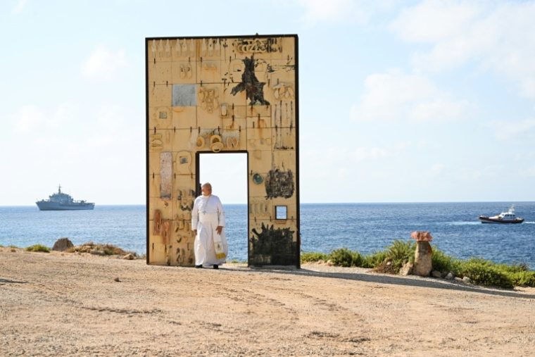 Le pape Léon XIV devant la "Porte de l'Europe", créée par l'artiste italien Mimmo Paladino, lors de sa visite sur l'île italienne de Lampedusa, le 4 juillet 2026 ( AFP / Tiziana FABI )