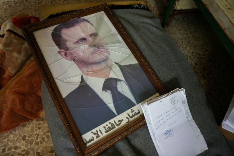 Un portrait brisé du président syrien déchu Bachar al-Assad ( AFP / OMAR HAJ KADOUR )