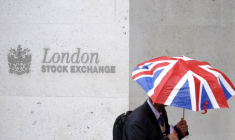Un travailleur s'abrite de la pluie alors qu'il passe devant la Bourse de Londres (London Stock Exchange).