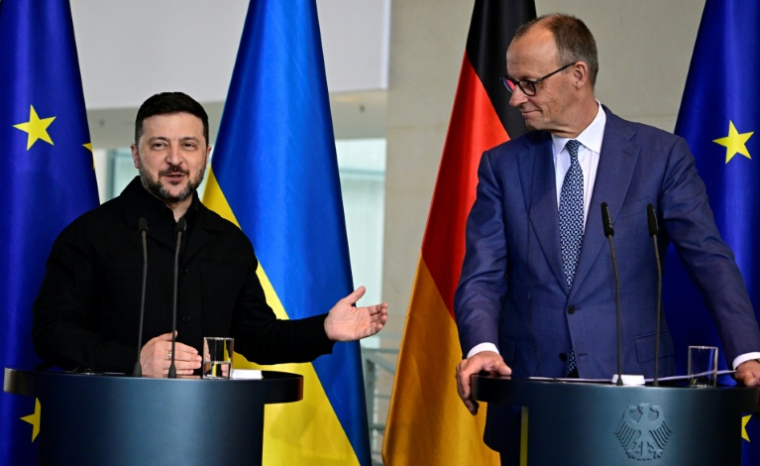 Friedrich Merz (d) et Volodymyr Zelensky (g) en conférence de presse à Berlin le 14 avril 2026 ( AFP / Tobias SCHWARZ )