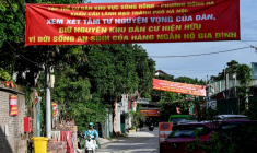 Des banderoles de protestation contre un vaste projet de réaménagement suspendues au-dessus d'une rue d'un quartier de Hanoï, le 19 juin 2026 au Vietnam ( AFP / STR )