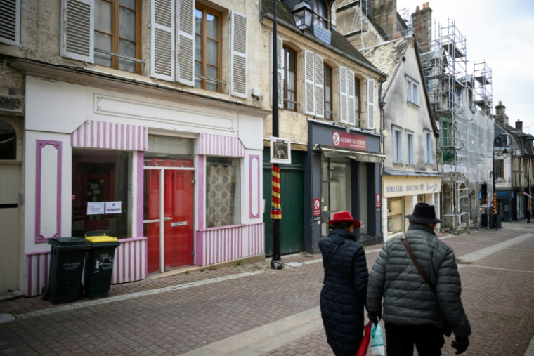Des piétons passent devant un magasin fermé à Bourges, le 9 janvier 2026 dans le Cher ( AFP / Loic VENANCE )