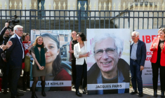 Cécile Kohler (3e G) et Jacques Paris (2e D) devant leurs portraits décrochés des grilles de l'Assemblée nationale, à Paris le 14 avril 2026 ( AFP / ALAIN JOCARD )