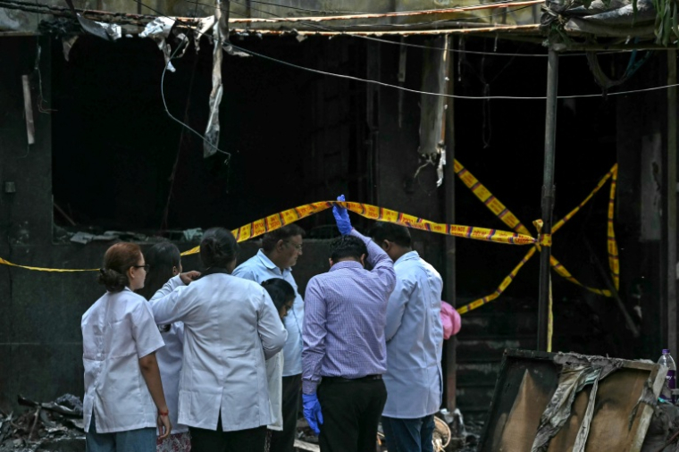 Des enquêteurs sur le site d'un incendie survenu dans un hôtel bon marché à New Delhi, le 3 juin 2026 en Inde ( AFP / Arun SANKAR )