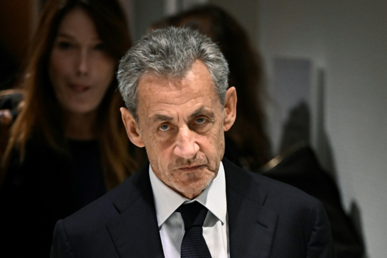 L'ancien président Nicolas Sarkozy, accompagné de son épouse Carla Bruni, quitte le tribunal de Paris après le verdict du procès libyen pour financement illégal de sa campagne de 2007, le 25 septembre 2025 ( AFP / JULIEN DE ROSA )