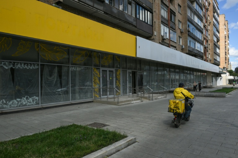 Un livreur passe devant la façade d'une enseigne fermée, à Moscou, le 28 juin 2026 ( AFP / Igor IVANKO )