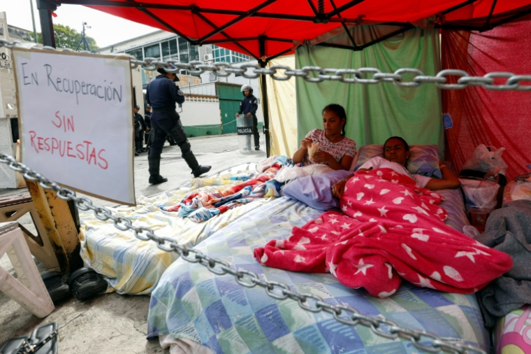 Les proches des prisonniers politiques, qui ont mené une grève de la faim se reposent devant la prison de la Zone 7 de la Police nationale bolivarienne (PNB) à Caracas, le 20 février 2026 ( AFP / Pedro MATTEY )