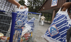 Des clients emballent des marchandises dans des sacs en plastique sur un parking