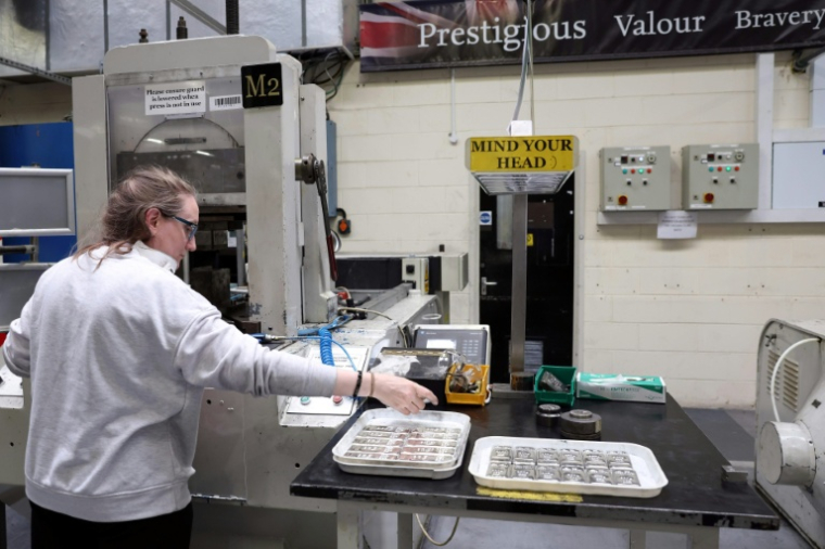 Cette photo, prise le 30 juin 2026, montre un employé retirant des lingots d'argent d'un dispositif de manutention à la Royal Mint de Llantrisant, dans le sud du pays de Galles ( AFP / Darren Staples )