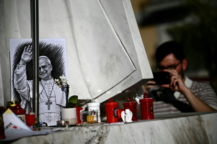 Un portrait au fusain du pape Léon XIV déposé au pied de la statue de Jean-Paul II, devant l’hôpital Gemelli où le souverain pontife est en convalescence, le 15 octobre 2026 à Rome ( AFP / Filippo MONTEFORTE )